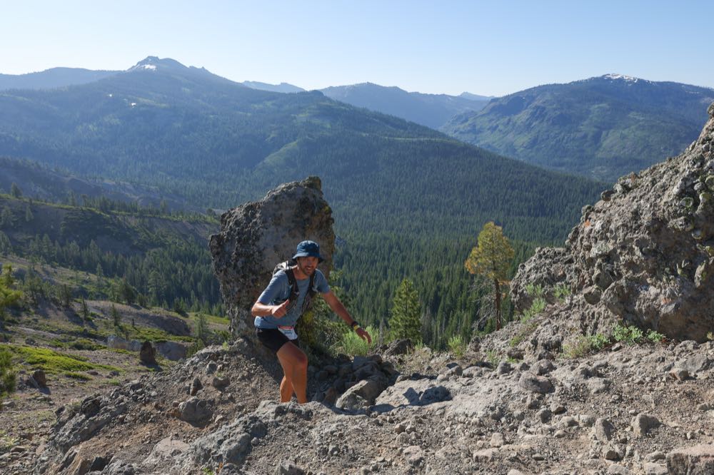 Bill climbing Cougar Rock during the Western States 100, with the
              forested Sierra Nevada stretching out behind him.